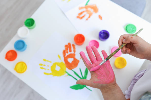 istock Children's art workshop, the child makes a handprint with paints 1505881325