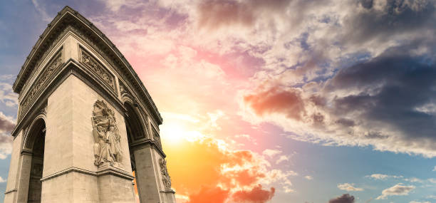 Arc de Triomphe (against the background of a sky at sunset), Paris, France. The walls of the arch are engraved with the names of 128 battles and names of 660 French military leaders (in French) Arc de Triomphe (against the background of a sky at sunset), Paris, France. The walls of the arch are engraved with the names of 128 battles and names of 660 French military leaders (in French) names of marbles stock pictures, royalty-free photos & images