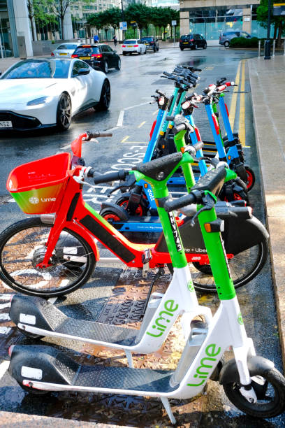 London, UK.  July 30th 2021.  Electric scooters and cycle parked in the street available for public hire using  a mobile phone app, Isle of Dogs, London.