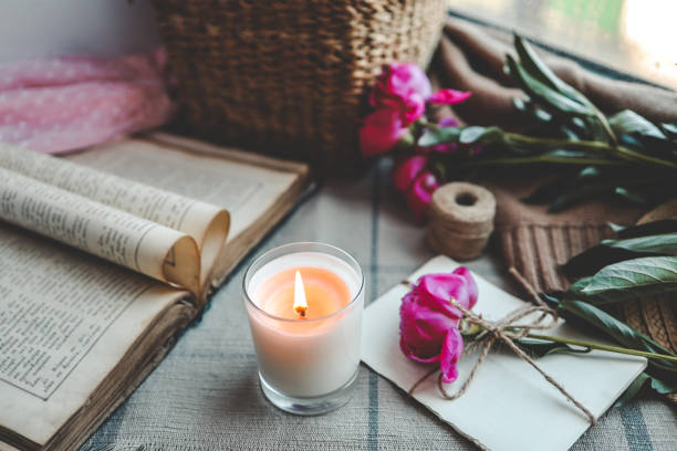 istock Burning candle and pink peonies, vintage aesthetic 1505956180