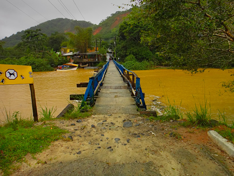 Wooden bridge with blue handrails for pedestrians crossing the Una River - SAO SEBASTIAO,  SAO PAULO,  BRAZIL.