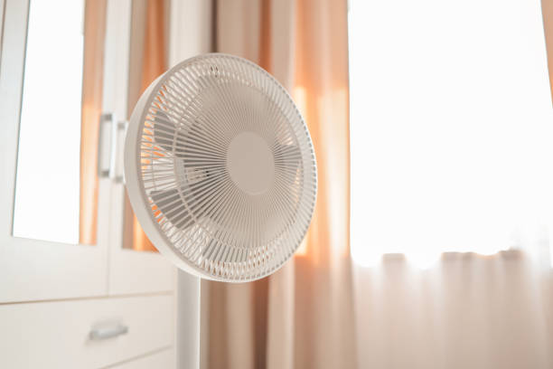 White desktop electric fan on light white room. Minimal concept with copy space