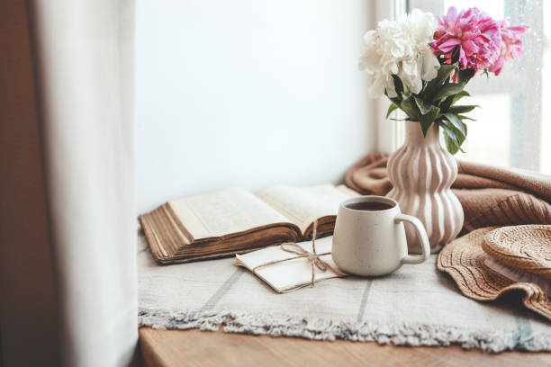 istock Cup of tea, straw hat, open book and peonies, spring still life 1505973177