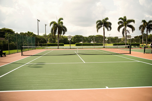 Empty tennis court outdoors in Florida. No people. Palm trees in the background. Horizontal full length shot with copy space. This was taken in Florida, USA.
