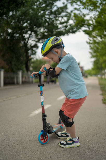 istock Little boy riding scooter. Kids ride kick board 1506005868