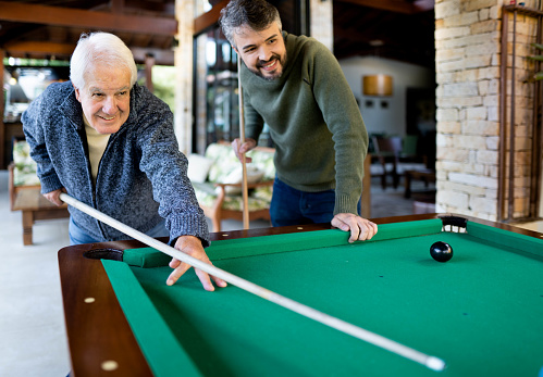 istock Senior man and his son playing a pool game together at home 1506005877
