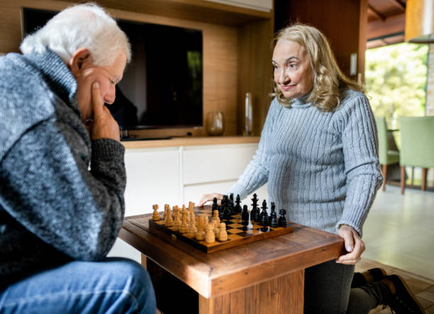 istock Senior woman playing chess with her husband at home 1506005906