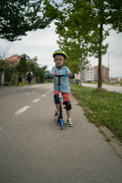 istock Little boy riding scooter. Kids ride kick board 1506007163