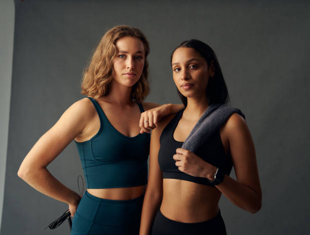 istock Young women in sportswear holding towel over shoulder while looking at camera in studio 1506021025
