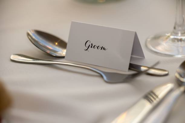 istock Place card is set atop a spoon and fork, both made of gleaming silver 1506106440
