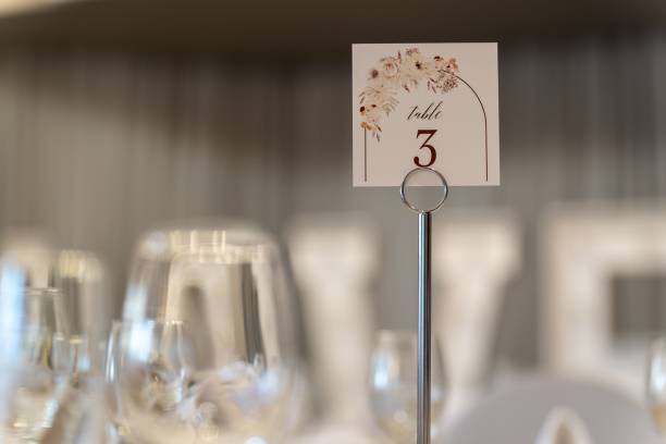 istock Wedding table with clear glasses topped with a card featuring white lettering that reads 
