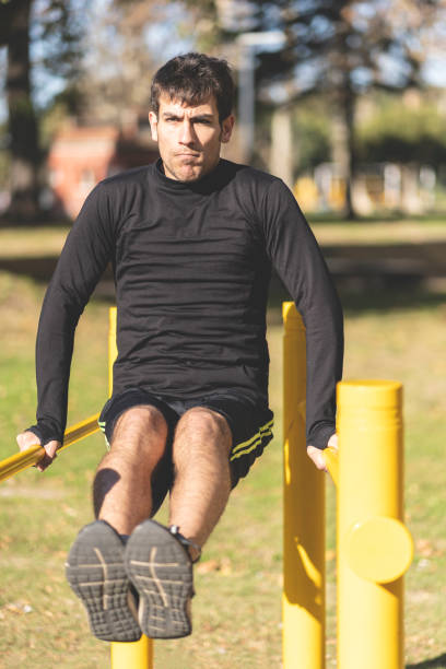 istock Fit young man doing push ups on horizontal bar outdoors 1506156399