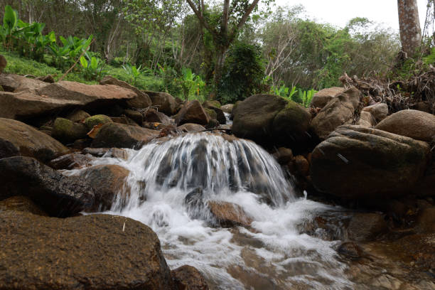 The waterfall has less water due to the dry summers in Thailand.