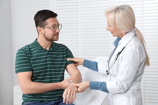 Doctor checking patient's pulse during consultation in clinic