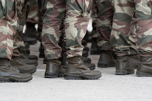 Soldiers in a relaxed position during the ceremony. Military unit. Military camouflage outfit. Soldier shoes.