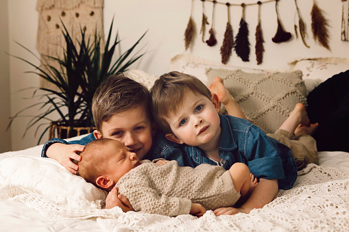 An image of a two little boys, ages five and three, with their newborn brother.