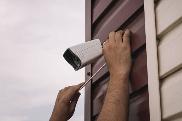 istock male technician is doing maintenance work by inspecting and cleaning an outdoor security surveillance camera on top of the building 1506271048