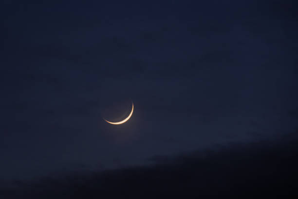 istock Young moon in the initial phase on a dark night sky 1506275345