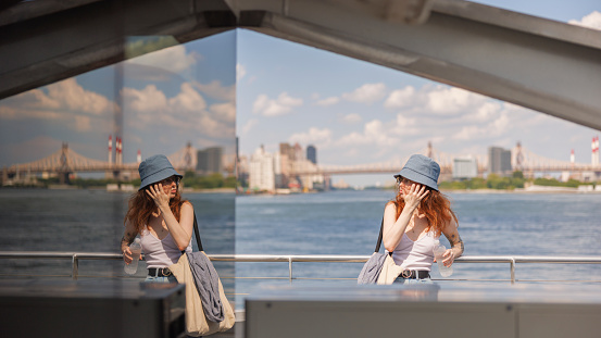 On the East River in New York City, a young woman is riding a ferry.