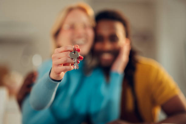 istock Selective focus on the woman's hand with the apartment keys while an affectionate multicultural couple is hugging. 1506278956