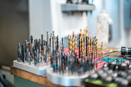 Close up on many varieties of milling bits used in a CNC machine in a factory.
