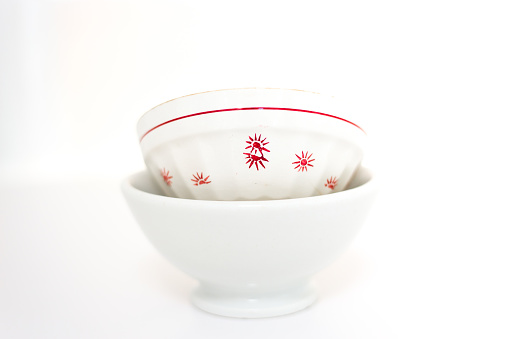 Stack of various English vintage porcelain teacups with floral decoration on dark background.