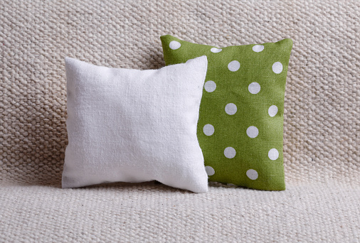 White and green cushion with polka dots on the sofa