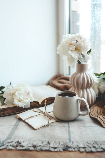 istock Cup of tea, straw hat, open book and peonies, spring still life 1506341167