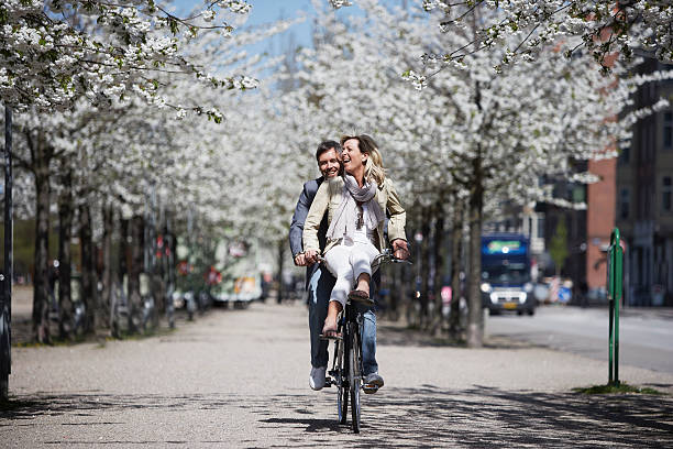 homem andando com a namorada na bicicleta - urban scene women adventure city - fotografias e filmes do acervo