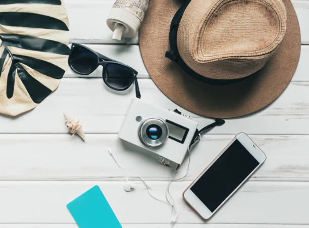 istock empty phone screen, camera, beach hat and sunglasses on a white wooden floor 1506400461