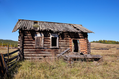 An abandoned wooden old house. The deserted village.