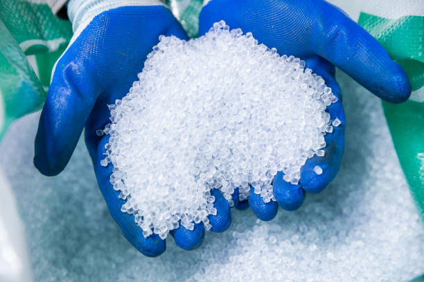 Gloved hand holds polypropylene granules, industrial material, plastic granules