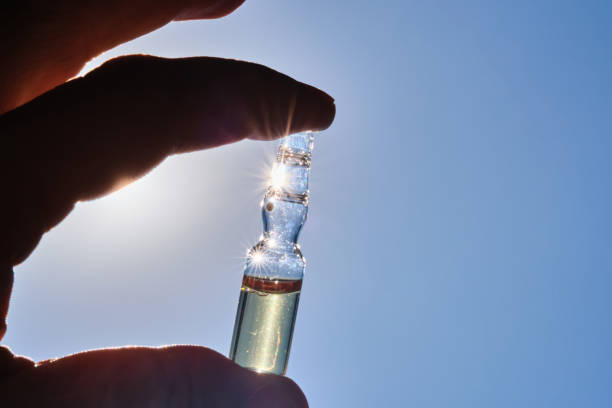 istock Ampoule in hand against the blue sky. 1506475502