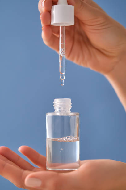 istock Serum with a pipette in female hands on a blue background. 1506476009