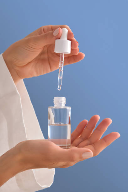 istock Serum with a pipette in female hands on a blue background. 1506476520