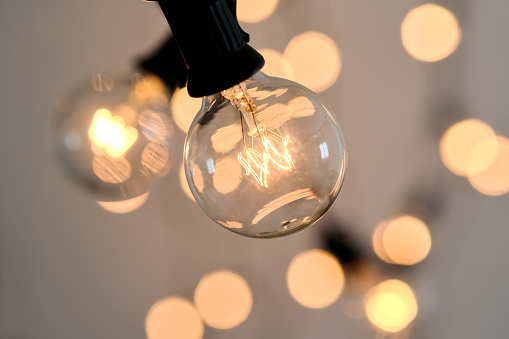 Incandescent light bulb with bokeh on background.