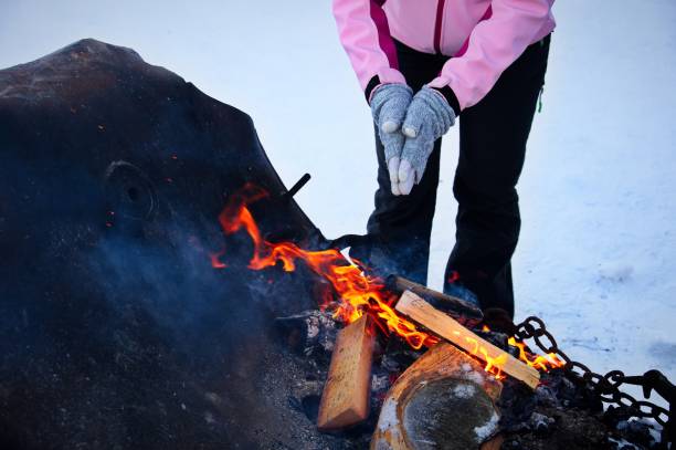 istock Midsection of woman heating hands over open flame 1506524344
