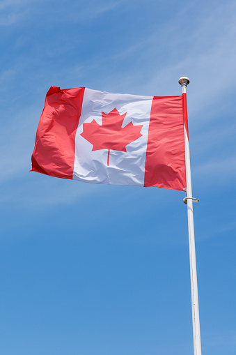 Canada flag waving in the wind on blue sky