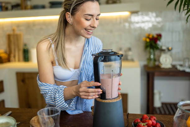 istock Young woman preparing smoothie for breakfast in her kitchen 1506561376