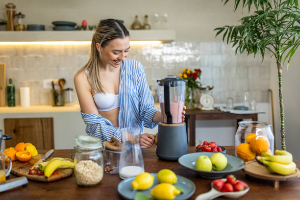 istock Young woman preparing smoothie for breakfast in her kitchen 1506561736