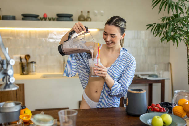 istock Young woman preparing smoothie for breakfast in her kitchen 1506562984