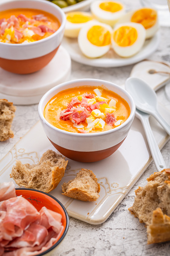 Salmorejo - raw tomato soup with ingredients on a kitchen table,  spanish cuisine for hot summer