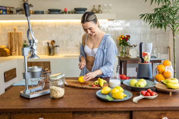 istock Happy woman slicing fruit while preparing smoothie in the kitchen 1506573327