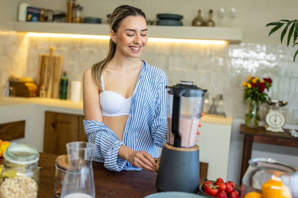 istock Young woman preparing smoothie for breakfast in her kitchen 1506577084