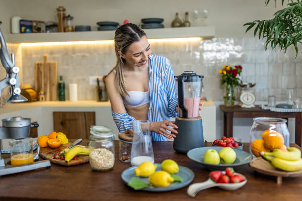 istock Young woman preparing smoothie for breakfast in her kitchen 1506590948