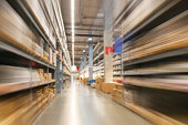 The movement rushes forward quickly. A blurred image of a warehouse full of empty cardboard boxes stacked on the shelves.