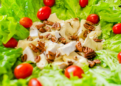 delicious salad plate with cheeses, cherry tomatoes and walnuts