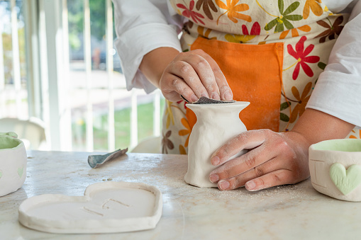 Ceramic artist sanding