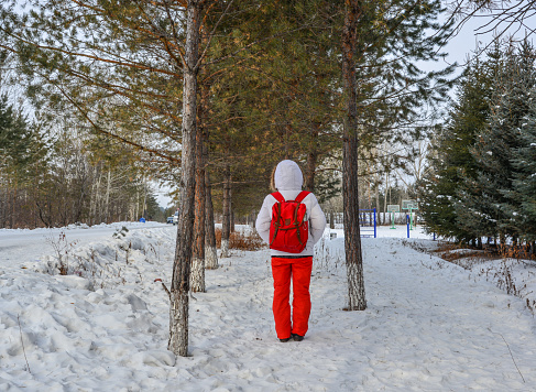 A woman walking on snow road at deep forest in winter.