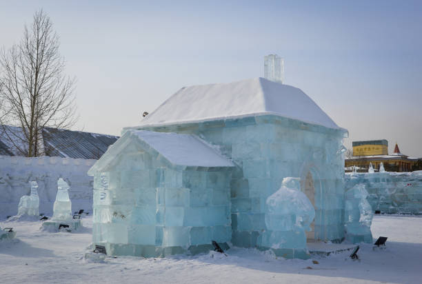 Women working with work tool, cutting ice block, making ice sculpture. Selective focus to ice sculpture.